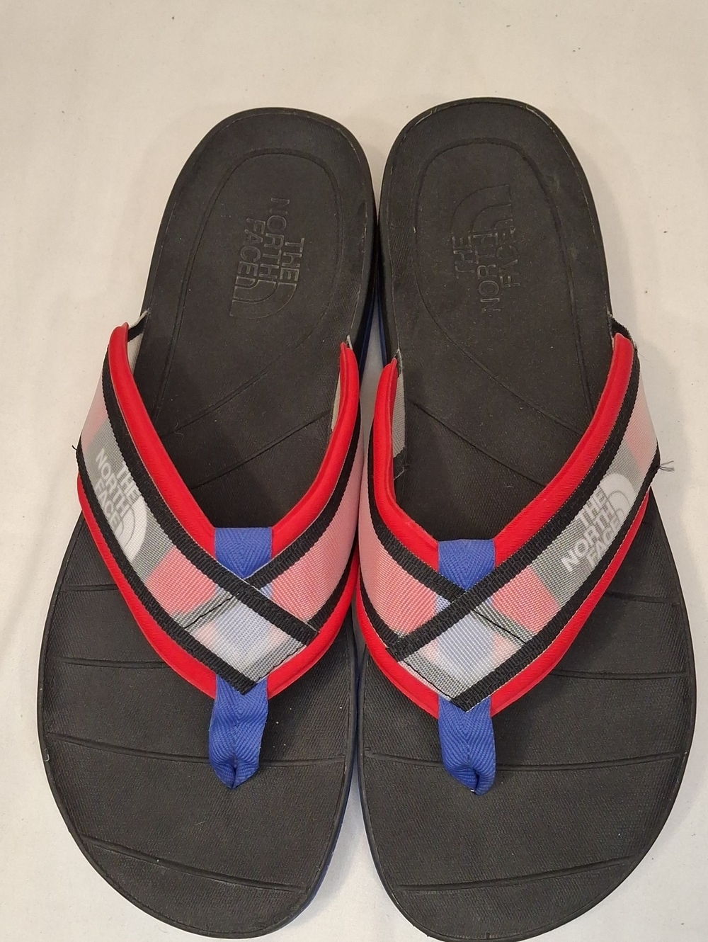 The North Face Black ThongFlip Flops. Red,Blue,Black Plaid Straps. Lightly Worn.